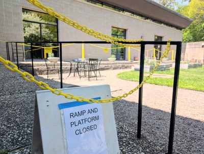 Chain roping off a ramp and raised walkway in the library courtyard, with a sign "Ramp and Platform Closed"