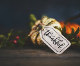Fall pumpkins with a note and the word "thankful" written on it