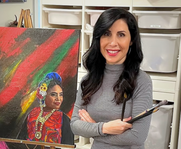Lisa Damico standing next to a painting of theirs.