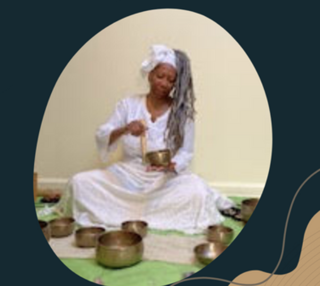 Beverly Aminata Spencer sitting, playing a singing bowl